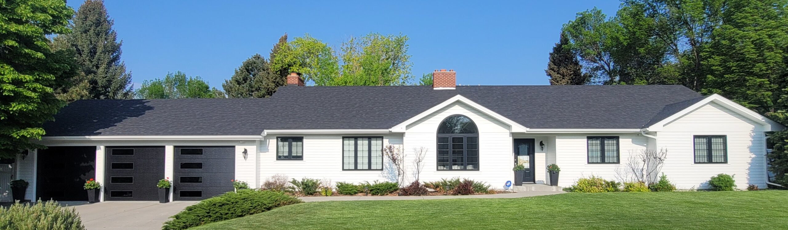 Full exterior work. New white siding, black trim, garage doors, exterior doors, windows, gutters, and roof.